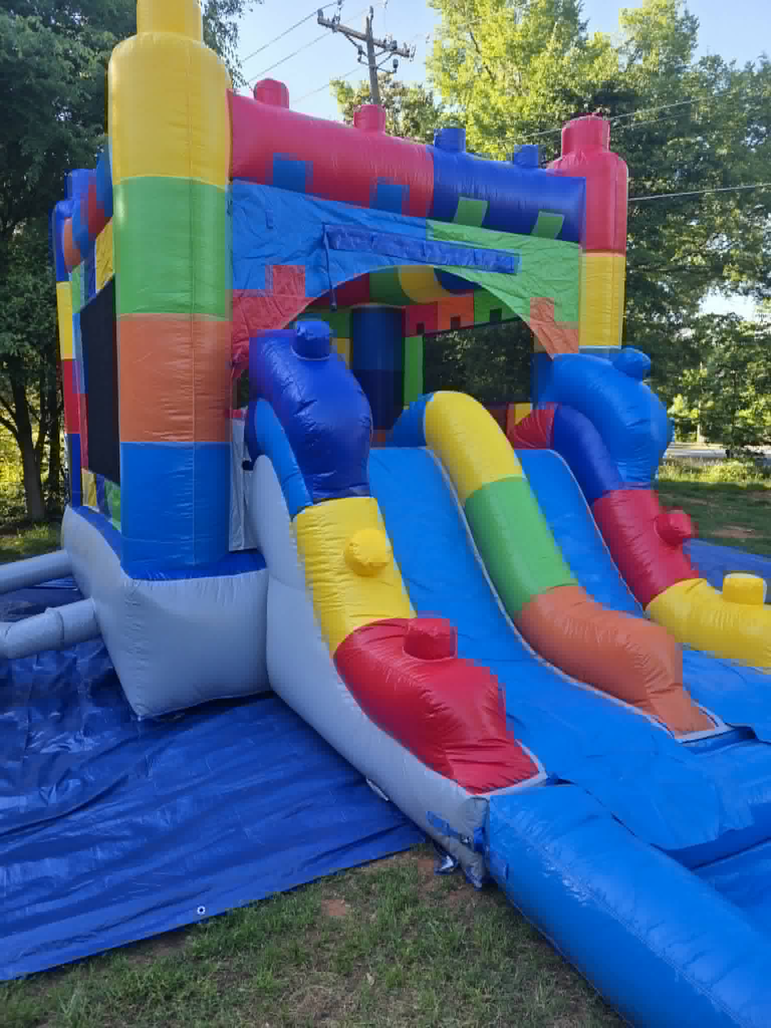 14 by 26 foot dual wet/dry slide and bounce house combo in bright primary colors set up on a lawn